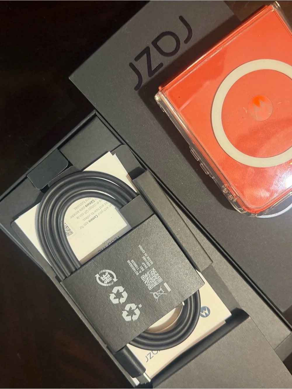 Motorola black smartphone with clear case and orange accents